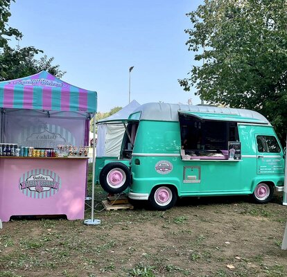 Gazebo pieghevole 2x2 personalizzato a strisce rosa e verde acqua con pareti laterali. Il gazebo viene utilizzato insieme a un furgoncino per vendita dolci e presenta il logo Dalila's street backery