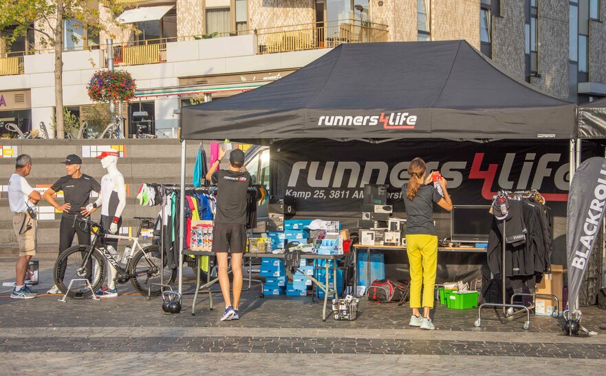 Gazebo promozionale nero 4,5x3m personalizzato con logo, parete laterale e beachflag per stand all'aperto Runners4life.