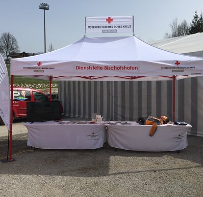 Gazebo pieghevole 4,5x3m bianco con struttura rossa personalizzato con logo, banner e bandiere per stand Croce Rossa