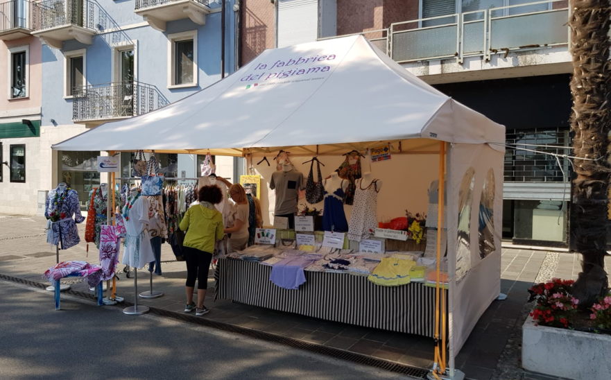 Gazebo pieghevole 4,5x3 m ecru con pareti laterali intere e con finestra e tettoia per la vendita di vestiti de La Fabbrica del Pigiama.