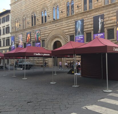 Gazebo pieghevole bordeaux 4x2 m con parete laterale intera e pesi per il fissaggio. Il gazebo è personalizzato con logo "il bello in piazza" ed è utilizzato da un Comune per un evento culturale in città