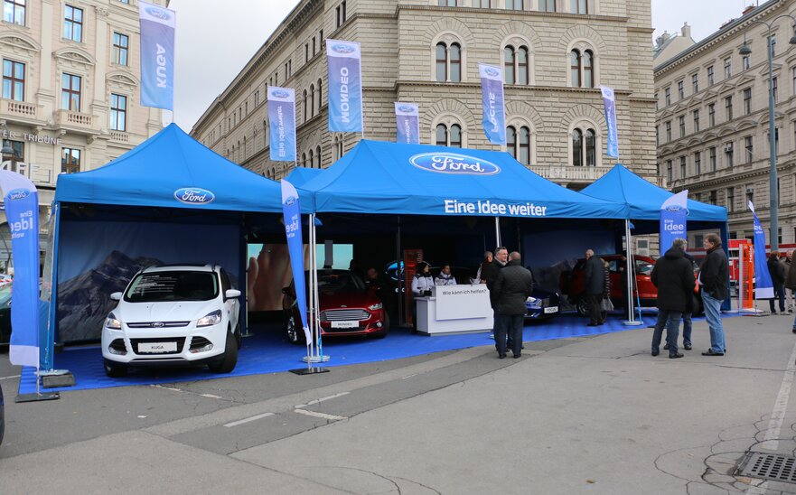 Gazebo pubblicitario per fiera 8x4 m blu con logo Ford e bandiere personaliazzate