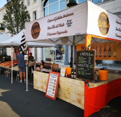 Una tenda street-food con il tetto stampato con il logo La Mule. Dotato inoltre di una parete laterale rossa con finestra panoramica. Accanto ad esso, sulla sinistra, c'è un altro stand di vendita. 