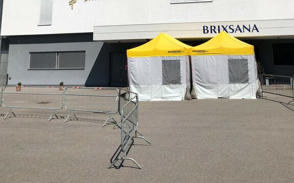 Pre-Triage Tent with a yellow roof in front of the private clinic Brixana.