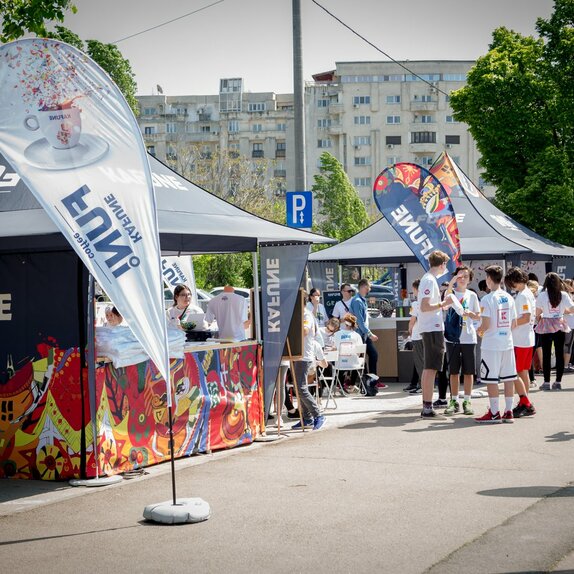 Faltpavillon 3x3 m mit individuellem Aufdruck und Kafune-Logo mit vollen Seitenwänden, halbhohen Seitenwänden mit Theke und individuellen Fahnen. Die Pavillons werden mit 28 kg Gewichten am Boden befestigt.