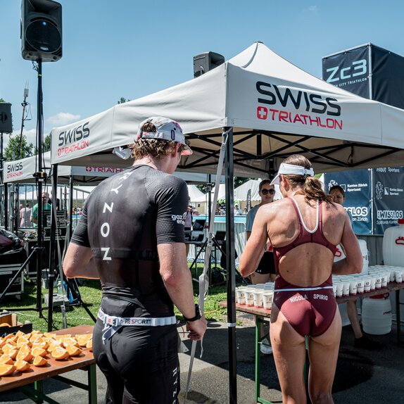 The picture shows two personalised 3x3 folding gazebos. Under them are refreshment drinks for the athletes.