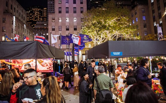 Event with presentation of various exhibitors with Mastertent modular system Square folding tents in black in front of a skyscraper backdrop with many visitors at the individual stands