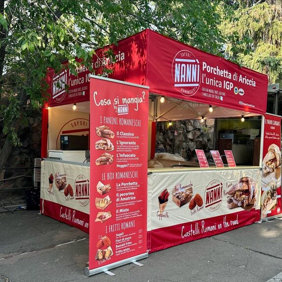 Ein roter Faltpavillon mit Flachdach und personalisiertem Design steht auf einer Straße.