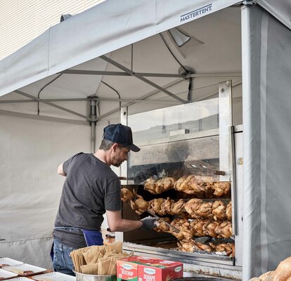 Koch kocht den Spieß bei einer Veranstaltung unter einem feuerfesten und feuerfesten Küchenzelt von Mastertent