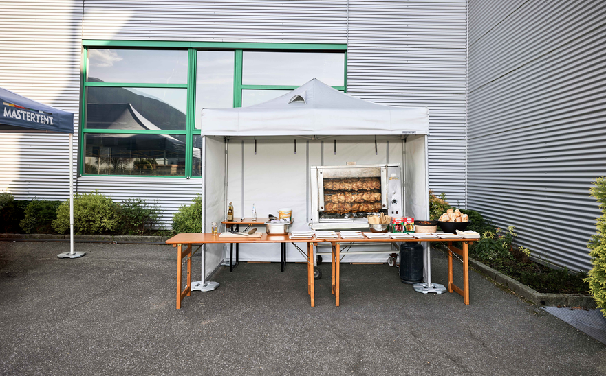 Spit-roasted chicken cooked under a Mastertent fireproof kitchen gazebo at an event 