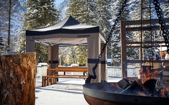 Gazebo pieghevole Mastertent invernale 3x3m in tessuto Loden verde e marrone sulla neve vicino a un falò