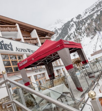 Gazebo esterno Mastertent 3x3m con copertura Loden per entrata hotel di montagna di lusso in inverno con la neve. Colori alpini marrone e rosso.