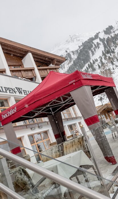 Gazebo esterno Mastertent 3x3m con copertura Loden per entrata hotel di montagna di lusso in inverno con la neve. Colori alpini marrone e rosso. Atmosfera montana e natalizia.