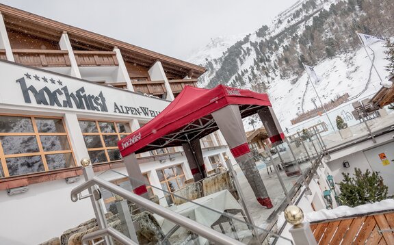 Gazebo esterno Mastertent 3x3m con copertura Loden per entrata hotel di montagna di lusso in inverno con la neve. Colori alpini marrone e rosso. Atmosfera montana e natalizia.