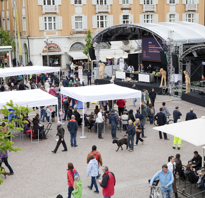 Tanti gazebo pieghevoli bianchi su misura con tetto piano ad un festival.