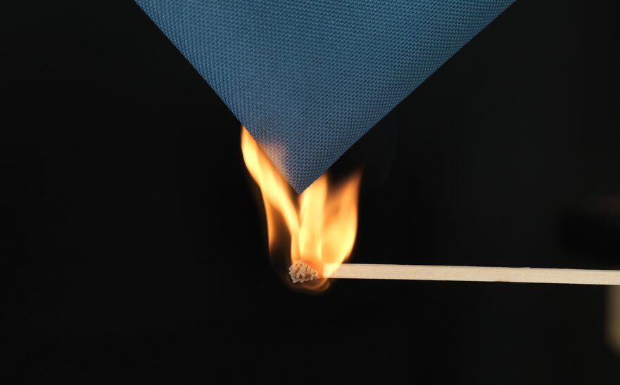 A burning match is used to ignite the blue fabric of the gazebo. 