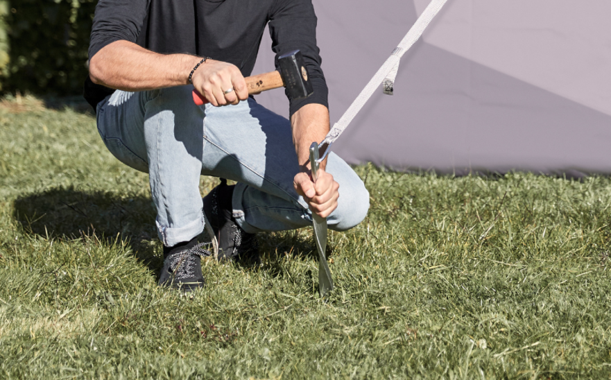 Fixing gazebo to a lawn with pegs and tension straps 