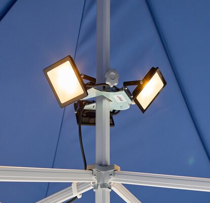 Three LED spotlights are mounted on the blue gazebo. The LED spotlights are all on.